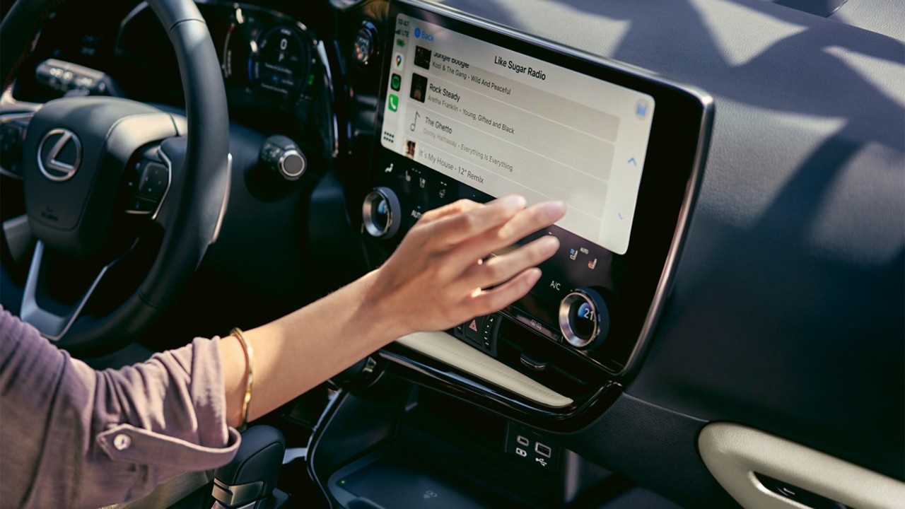 A person interacting with a Lexus touchscreen display